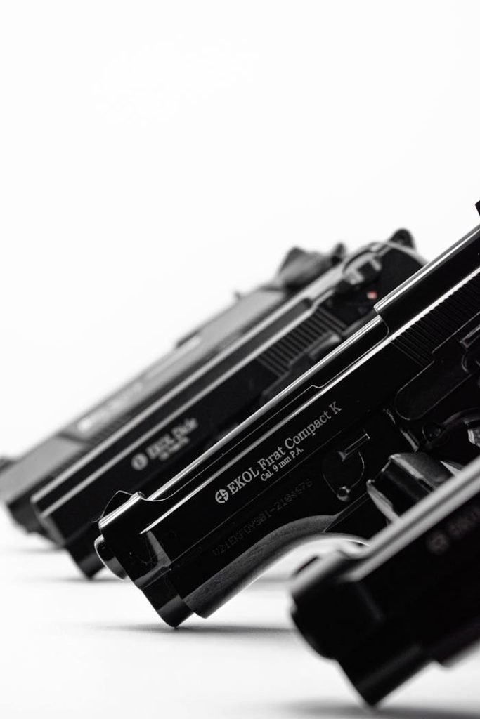 Crafting Captivating Headlines: Your awesome post title goes here Monochrome image showcasing a lineup of handguns in a diagonal arrangement.